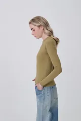 Remera de manga larga ajustada al cuerpo, color blanco, con cuello redondo bajo y tejido acanalado.