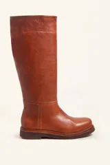 Bota de caña alta confeccionada en cuero vacuno suave, con diseño minimalista y suela de goma robusta. Presenta costuras visibles en la zona del empeine y un taco bajo cuadrado.