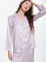 Camisa de dormir de satén con cuello solapa, cierre frontal con botones y mangas largas. Presenta un corte holgado y fluido.