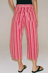 Jeans capri de tiro medio y diseño balloon, con patrón de rayas verticales rojas y blancas, trabillas en la cintura y bolsillos delanteros y traseros.