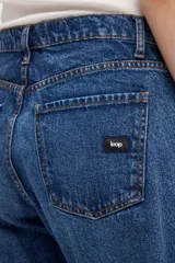 Jean de tiro alto con silueta tipo globo, ajustado en la cintura y con piernas holgadas que se estrechan hacia el bajo.