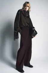 Blusa de la colección Zara Woman, confeccionada en hilatura de viscosa con estampado de cuadro vichy en tonos marrón y negro. Presenta cuello solapa, manga larga con puño y bajo ajustable con cordones. Cierre frontal con botones.