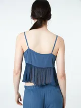 Top azul con breteles finos, escote en V y detalle de volado en el bajo busto.