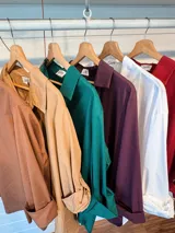 Camisa de algodón de corte oversize y calce relajado, con cuello camisero clásico, mangas largas con puños y ruedo irregular más largo en la parte posterior.