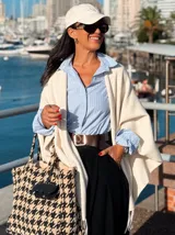 Camisa de manga larga con diseño de rayas verticales en tonos celeste y blanco. Presenta cuello clásico, cierre frontal con botones y mangas con puños acampanados con volados.