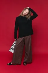 Sweater de tejido de punto negro con tramas de ochos en las mangas y laterales, cuello redondo a la base y mangas largas.