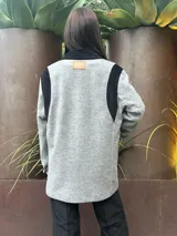 Tapado gris con detalles en pana negra en cuello, solapas, hombros y bolsillos.