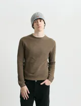 Sweater de punto con textura waffle, color negro, de corte clásico con cuello redondo y mangas largas con puños ajustados.