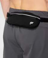 Riñonera deportiva negra Fabletics modelo The Running, con diseño ligero, banda reflectante en el frente, cierre con cremallera y correa ajustable.