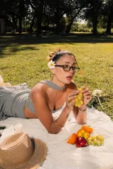 Top strapless de corte ajustado con estampado de cuadros vichy en blanco y negro. Presenta un cierre frontal con gancho metálico y un cuello tipo choker integrado en la misma tela.