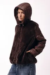 Campera con capucha, cuerpo de pelo sintético y mangas matelaseadas con cierre frontal.