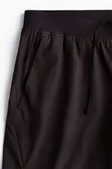 Short deportivo negro H&M en tejido funcional con tecnología DryMove™, de corte estándar, cintura elástica con cordón ajustable, bolsillos laterales y aberturas en el dobladillo.