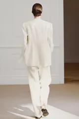 Pantalón de tiro medio de ZARA Woman Collection confeccionado en hilatura de viscosa. Cuenta con cintura con trabillas, bolsillos laterales, raya planchada y pierna recta con bajo asimétrico y aberturas. Cierre frontal con cremallera, botón y ganchos metálicos.