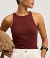 Blusa sin mangas de corte regular, confeccionada en tejido rib de algodón con cuello redondo. Presenta un diseño minimalista y anatómico, ideal para un look clásico.