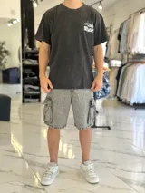 Remera oversize negra con efecto gastado, de manga corta, con estampa en la espalda que incluye texto y la ilustración de un auto clásico.