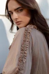 Blusa blanca de algodón suave, con mangas 3/4 y escote redondo con volados en el frente, mangas y escote.