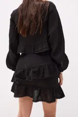 Minifalda azul de lino con dos volados superpuestos, terminación de encaje en los bordes.