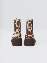 Botas estilo Chelsea de cuero vacuno rojo con grabado texturado tipo paisley, elásticos laterales negros y suela gruesa con taco de 5,5 cm.