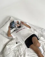 Remera blanca de manga corta, corte regular y cuello redondo, con gran estampado en la espalda de temática "Worldwide Tour" con una calavera y texto en rojo, azul y blanco.
