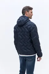 Campera de nylon matelaseada con capucha integrada, cierre frontal y diseño de costuras geométricas. Presenta un ajuste regular y es ideal para climas fríos.