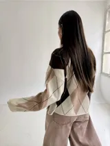 Sweater de punto con diseño de rombos en tonos marrón, beige y celeste, de corte holgado, cuello redondo y manga larga.