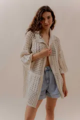 Saco calado negro tejido a máquina, con cuello tipo camisa y mangas 3/4.