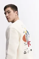 Buzo de algodón color crema, corte oversize, con escote redondo y puños. Presenta un estampado gráfico grande en la espalda con un globo aerostático y texto que incluye "SOME PEOPLE MIGHT THINK I'M WEIRD BUT, I DON'T CARE" y otros símbolos gráficos.