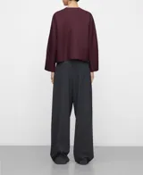 Camisa corta bordó de línea recta, con escote redondo a la base, manga japonesa y cierre frontal con botones. Cuenta con bolsillos delanteros de plastrón con solapa.