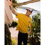 Remera de algodón color mostaza con cuello redondo, manga corta y estampa pequeña en el pecho con el logo de la marca.