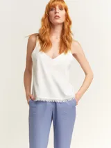 Musculosa verde agua con escote en V, breteles anchos con detalle de argollas de madera y ruedo con flecos.