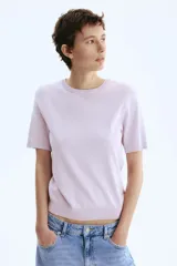 Remera de manga corta en punto fino color lila, con cuello redondo, puños y bajo en punto acanalado.