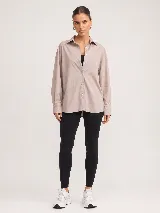 Camisa blanca de popelina oversize con cuello clásico, cierre frontal de botones y mangas largas con puños.