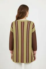 Cardigan de punto con diseño asimétrico, presentando un lado con estampado de rombos en tonos rosa, marrón y blanco, y el otro lado con rayas horizontales en verde oliva y marrón. Posee cuello en V, cierre frontal con botones y mangas largas con puños en contraste.