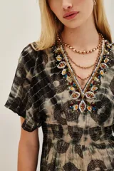 Vestido largo de viscosa con estampado tie-dye y motivos circulares, escote en V con detalle de pedrería, mangas cortas tipo mariposa y cintura entallada con elástico.