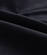 Campera tipo trucker de sarga color azul marino, con cuello de terciopelo al tono, cierre frontal de cremallera y bolsillo con cierre en el pecho.