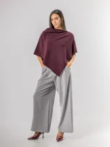 Poncho de corte holgado y diseño minimalista, confeccionado en tejido liviano de color beige, con cuello redondo y caída fluida.