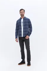 Camisa de manga larga confeccionada en viyela de algodón con diseño a cuadros en tonos verde oscuro. Presenta cuello clásico, cierre frontal con botones y bolsillo aplicado en el pecho.