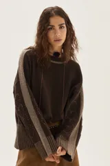 Sweater de tejido de punto color marrón chocolate, con diseño holgado y mangas largas. Presenta detalles de bandas laterales en tono beige con bordados artesanales y puños acanalados con hilos de lurex.