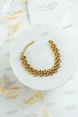 Pulsera dorada de acero quirúrgico con eslabones dobles entrelazados y cierre ajustable.