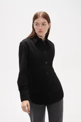 Camisa de jean negro con diseño de frunces verticales en el frente, cuello clásico, cierre frontal con botones y mangas largas con puños abotonados.