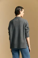 Polera de tejido de punto color blanco, con cuello alto acanalado, hombros caídos y detalle de costura vertical en el frente.