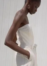 Mono largo color blanco de algodón estilo denim, con escote palabra de honor (strapless), pernera recta y un cinturón desmontable de la misma tela.