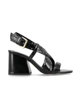 Sandalia de tiras cruzadas color negro con acabado charol, adornada con tachitas metálicas doradas. Posee taco cuadrado alto y tira ajustable al tobillo con hebilla metálica.