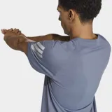 Remera deportiva Adidas Adi365 Climacool de color gris, con cuello redondo y mangas cortas. Cuenta con tecnología Climacool para absorción del sudor, las clásicas tres tiras reflectantes en las mangas y el logo de la marca en el pecho.