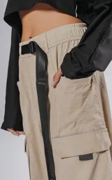 Pantalon cargo color vison de silueta oversize y pierna recta ancha. Cuenta con cintura elastizada, cinturón integrado con hebilla de seguridad, múltiples bolsillos laterales con solapa y detalles reflectivos.