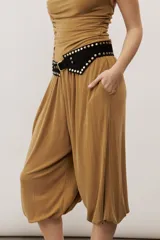 Pantalón holgado negro tipo bombacho, con cintura elástica y puños fruncidos en los tobillos.