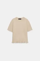 Jersey de punto de cuello redondo y manga corta, con detalle de volantes en el ruedo y en los puños.