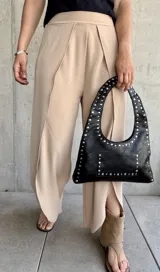 Pantalón color beige de corte palazzo con abertura lateral en la parte inferior de la pierna.