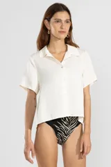 Camisa color crema de lino y tencel, de manga corta, con cuello camisero y cierre abotonado al frente.