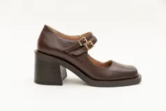 Guillerminas de cuero charol negro con punta cuadrada, taco ancho y correa sobre el empeine con doble hebilla dorada.